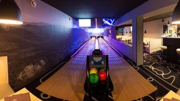 A bowling alley with a bar area and seating on the right.