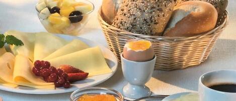 A breakfast setting with bread, fruit, cheese, and condiments.