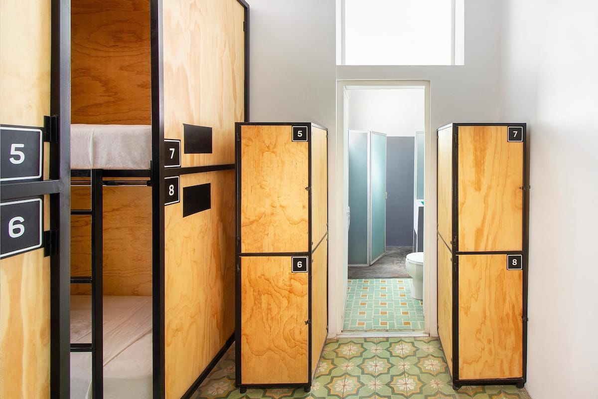 A corridor with wooden lockers numbered 5 to 8, leading to a bathroom.