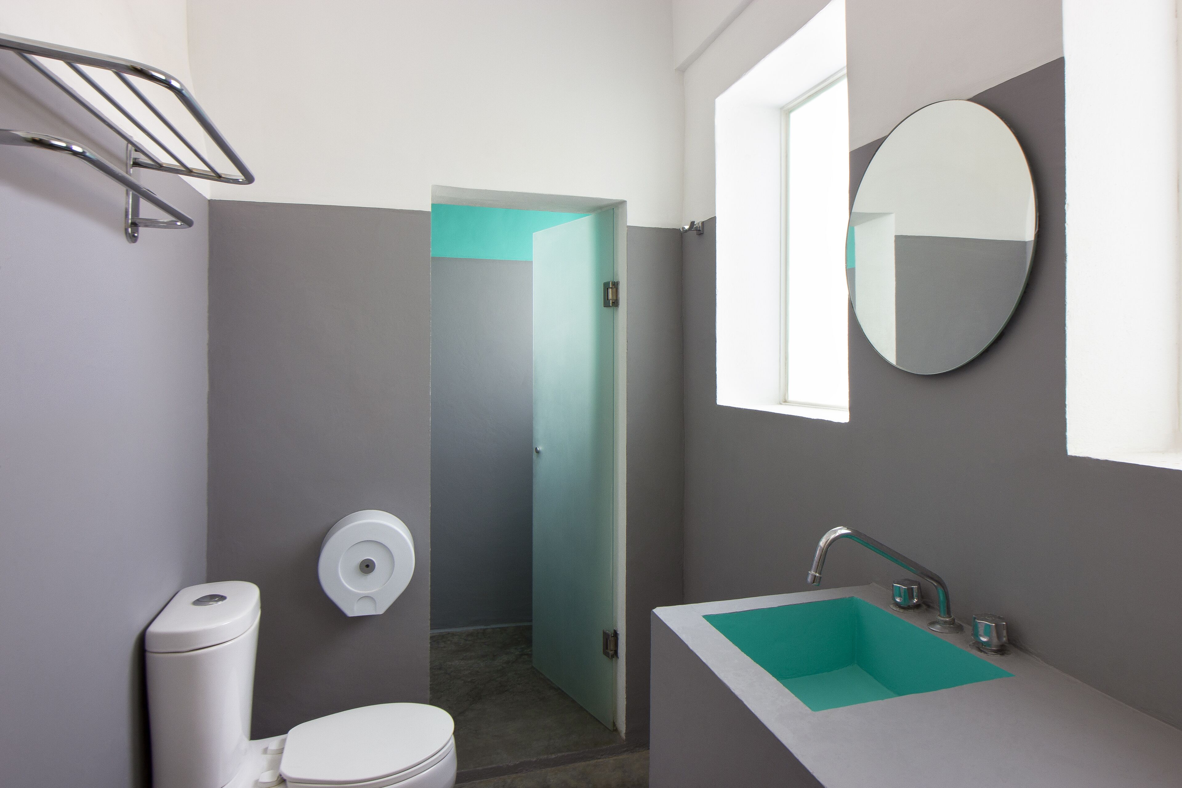 A modern bathroom with a toilet, sink, and mirror.