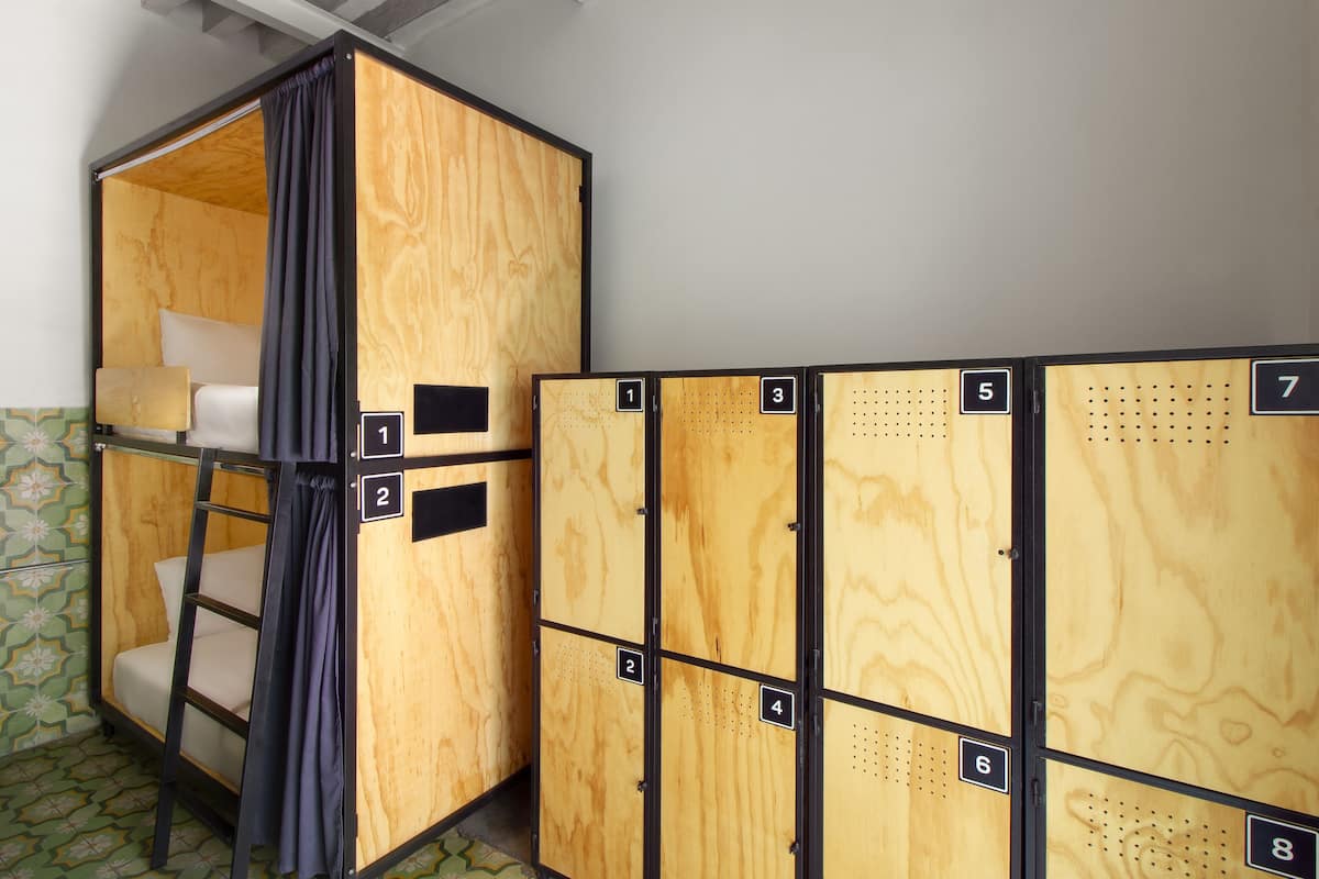 A set of bunk beds with a curtain, and adjacent lockers numbered 1 to 8.