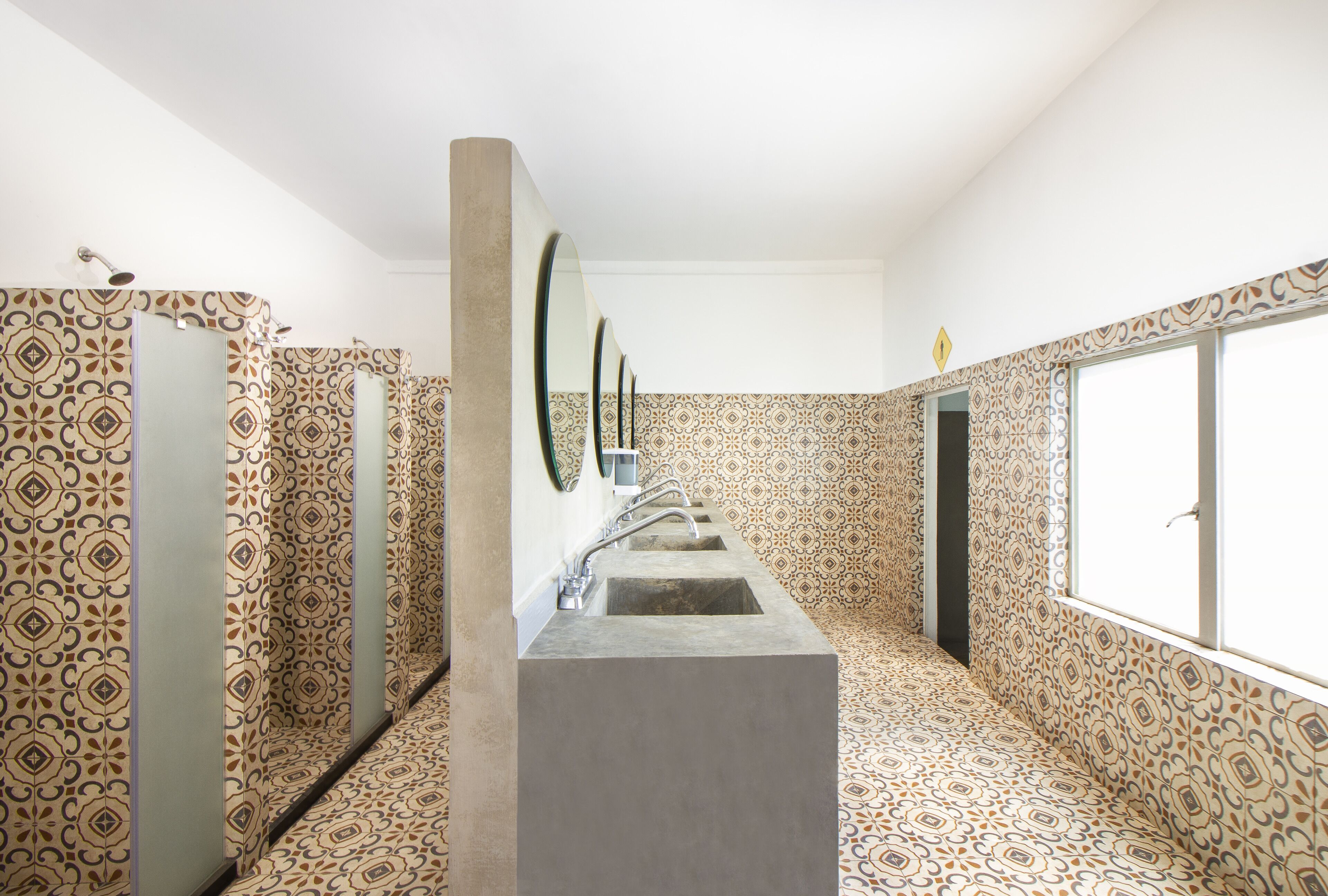 A bathroom with patterned walls, a central sink, and a window.