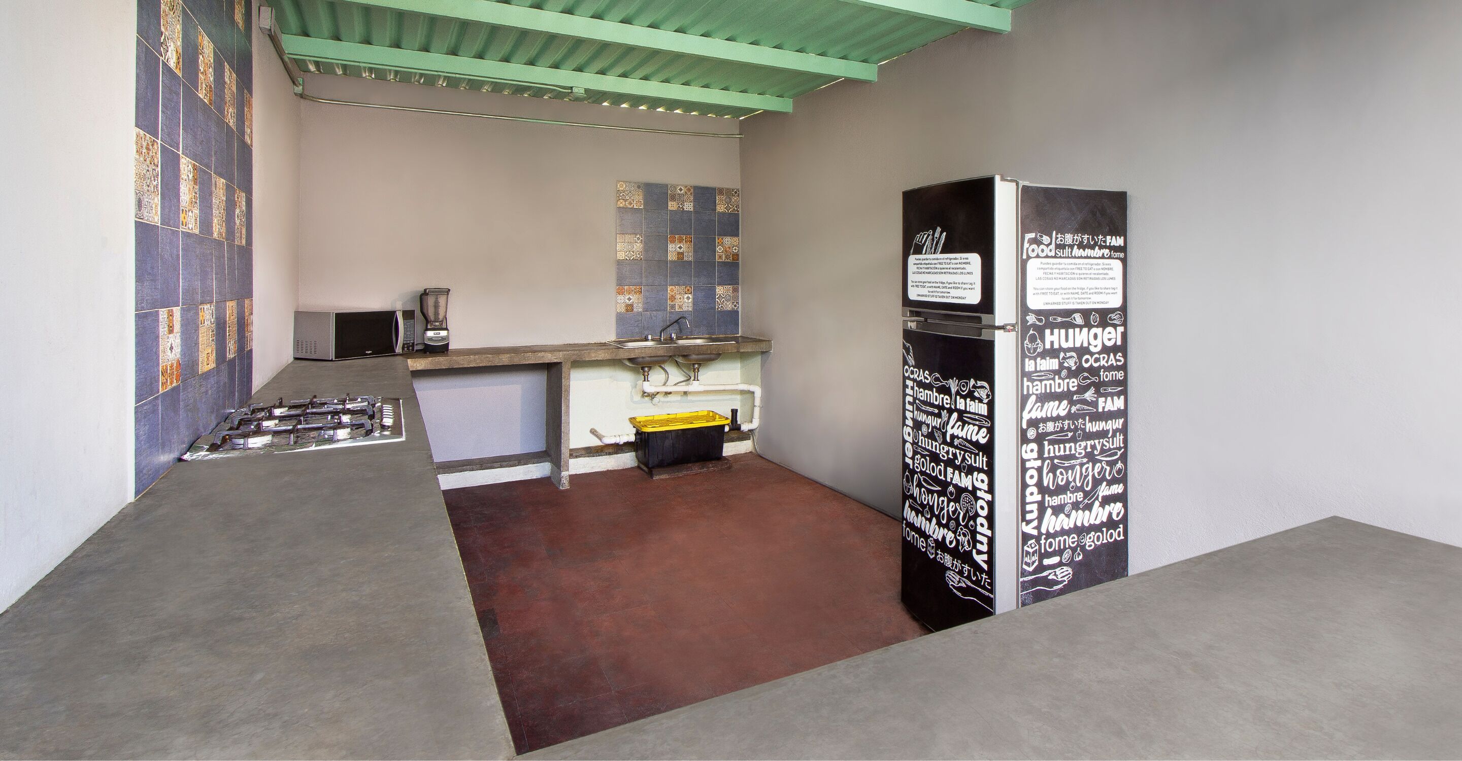 Una cocina con mostrador, pileta y refrigerador.