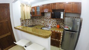 A kitchen with a built-in island, stainless steel appliances, and wooden cabinets.