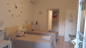 Habitació d'hotel amb dos llits, una taula petita, un microones i una finestra amb vista.