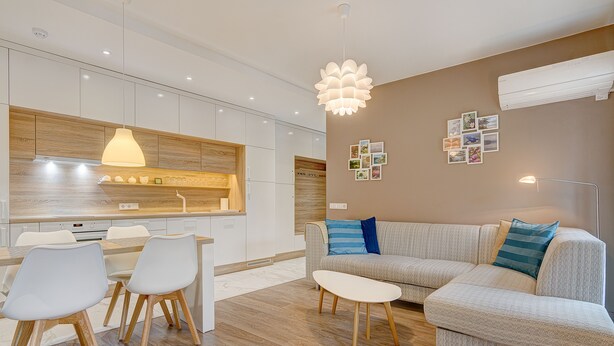 A modern kitchen with white cabinets, a wooden countertop, and a dining area with a white table and chairs. - Happy InnSide in central. Self check-in + free parking (Vilnius)
