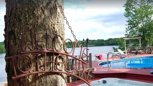 A tree with a 'WELCOME' sign, a hot tub, and a pool area with lounge chairs. - Pocono Lakefront Paradise, dock, hot tub, private pool and tennis court (pocono summit)