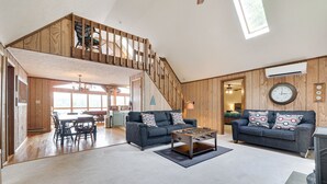 A spacious living area with two sofas, a coffee table, and a staircase leading to an upper level. - Pocono Lakefront Paradise, dock, hot tub, private pool and tennis court (pocono summit)