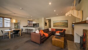 Una sala moderna con un sofá modular, una mesa de centro y un comedor con mesa y sillas.
