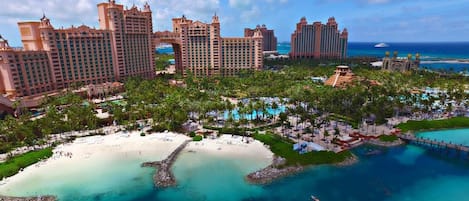 Um resort com vários edifícios altos, uma praia e um parque aquático.
