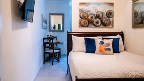 A bedroom with a bed, a desk, and chairs. - Walk to Beach, Restaurants  & Attractions (Nassau)