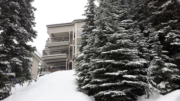 A building with multiple balconies and a snow-covered landscape.