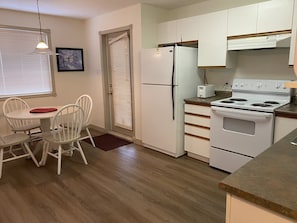Enjoy meals in this kitchen with oven, stovetop, and microwave, and dine at the adjacent table with four chairs.