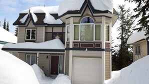 A two-story house with a snow-covered roof and a garage.