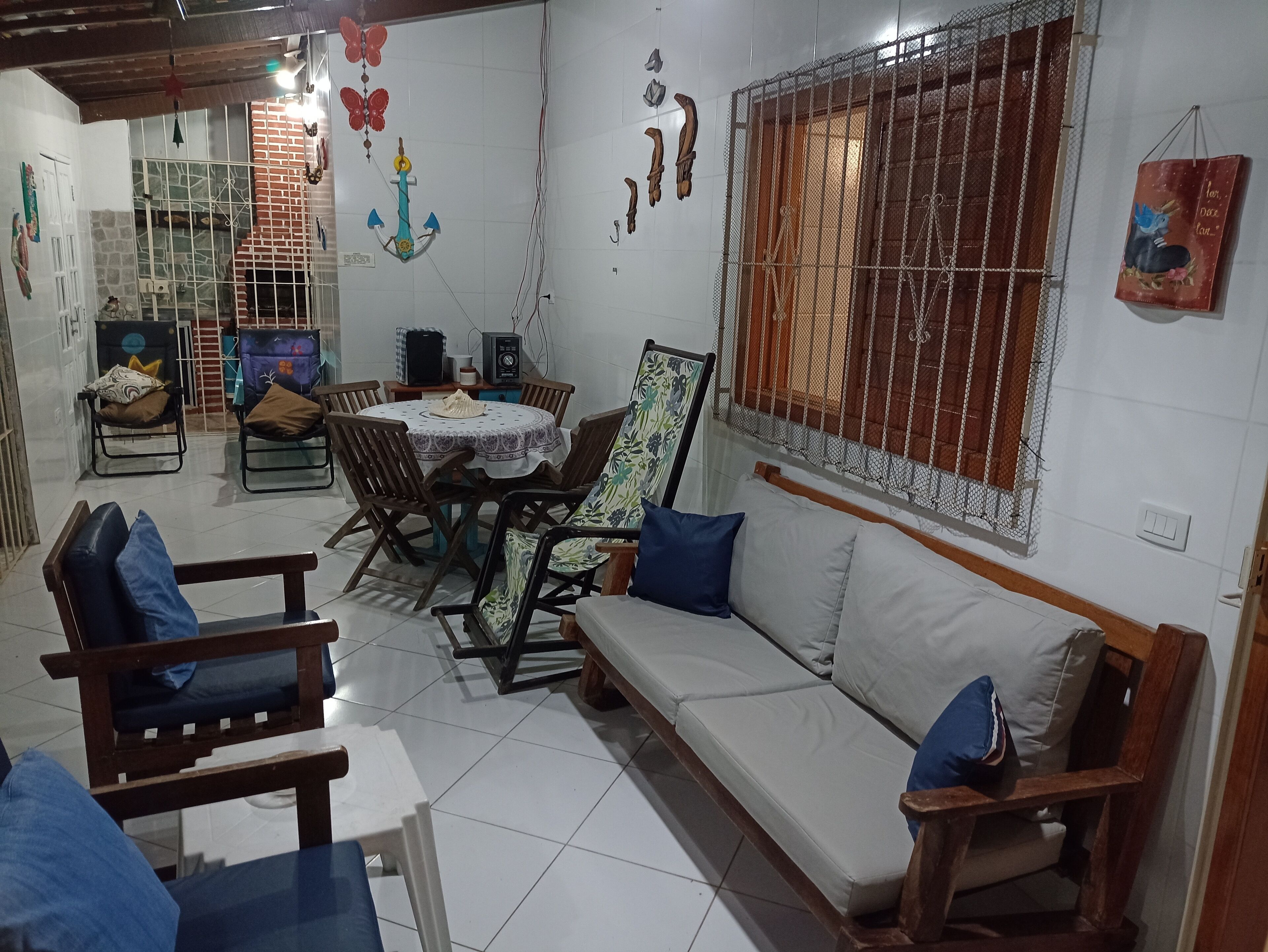 Un salon comprenant un canapé, des fauteuils, une table à manger et un téléviseur.