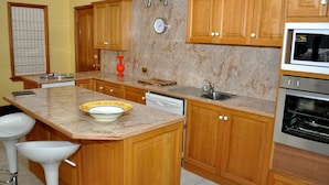 A kitchen with wooden cabinets, a sink, a dishwasher, and an oven.
