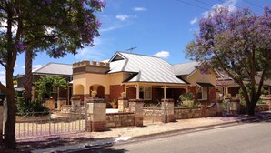 A two-story house with a brick facade, a tiled roof, and a stone entrance.