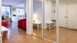 Una sala moderna con un sofá rojo, una mesa blanca y un separador de vidrio.