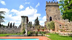 A historic stone building with a tower, a statue, and a swimming pool. - Panoramic castle with large pool on the walls. Ideal for weddings and events (Poggibonsi)