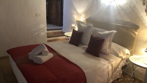 A bedroom with a bed, pillows, a red blanket, and a small table with a lamp. - Country holiday home - San jose (sant Josep de sa Talaia)