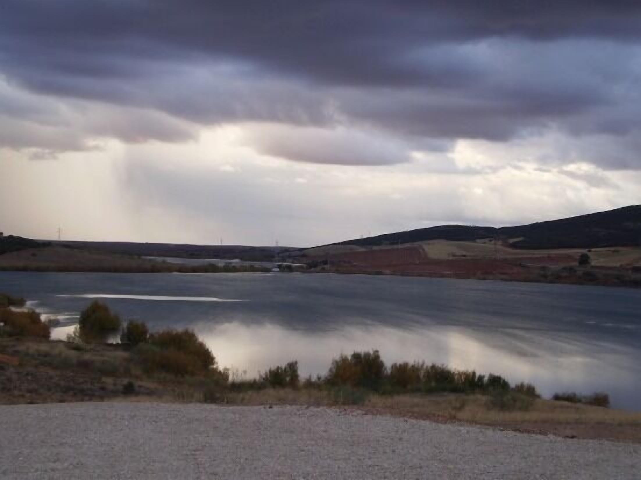 Un lac paisible sous un ciel nuageux.