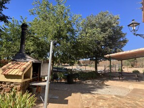 Un patio al aire libre con chimenea, asientos y una pérgola.
