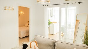 Un saló modern amb un sofà, un llit i un mirall gran.