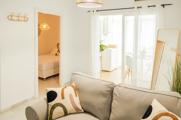 Una sala de estar moderna con un sofá, una cama y un espejo grande.