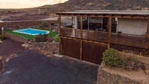 Un edificio de madera con piscina y vistas a un paisaje montañoso.