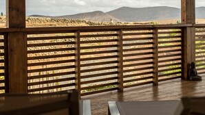 Una terraza de madera con vista a un paisaje montañoso.