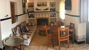 Una sala de estar acogedora con un sofá, sillones, una mesita y una chimenea.