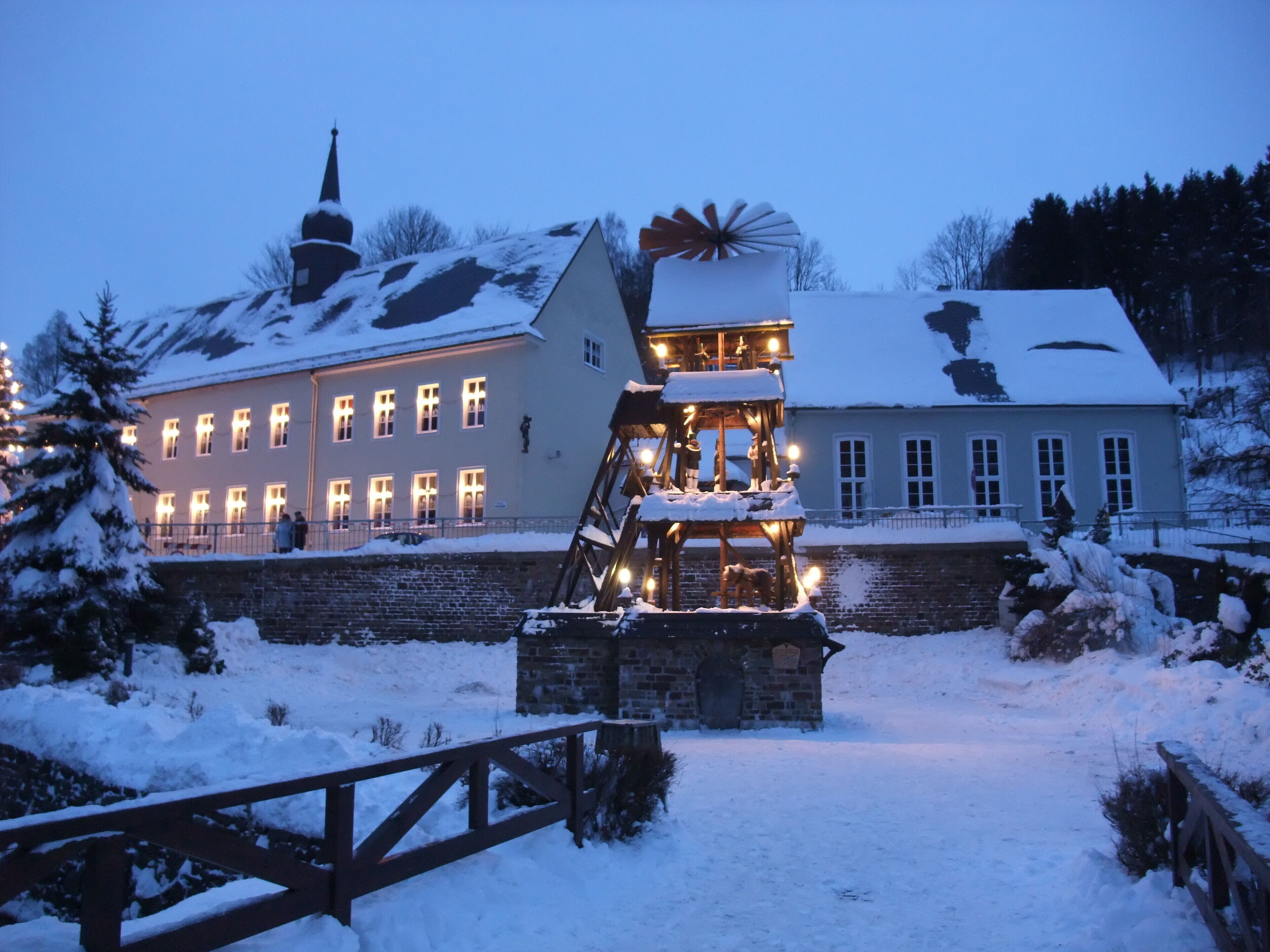A snow-covered building with a wooden structure in front, possibly a lookout or decorative feature.