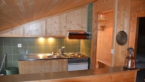 Una cocina con armarios de madera, una estufa y un fregadero.