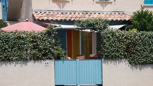 Un edifici amb una porta blava, un para-sol vermell i un senyal amb el número 48.