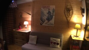 A cozy room with a grey sofa, a small table with a lamp, and a poster on the wall. - Ground level for 4 pers, superb setting 164 yards from the ski runs et the shops (Les Deux-Alpes)