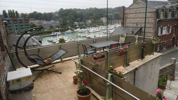 A balcony with a view of a marina, outdoor seating, and potted plants. - GITE F2 60 M2 WITH TERRACE ON PORT CLASSIFICATION PREFECTORAL 2 STARS        (Saint-Valery-En-Caux)