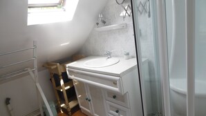 A modern bathroom with a skylight, a white vanity with a sink, and a glass shower enclosure. - GITE F2 60 M2 WITH TERRACE ON PORT CLASSIFICATION PREFECTORAL 2 STARS        (Saint-Valery-En-Caux)