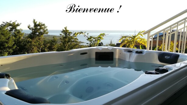 Un jacuzzi con vistas al mar y al verdor.
