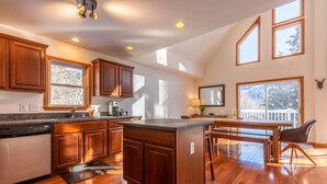 A spacious kitchen with wooden cabinets, a built-in dishwasher, and a large island. - Quiet Vermont Winter Getaway (Bridgewater)