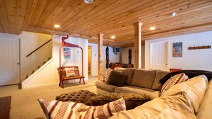 A cozy living room with a wooden ceiling, a staircase, a sofa, and a couch. - Quiet Vermont Winter Getaway (Bridgewater)