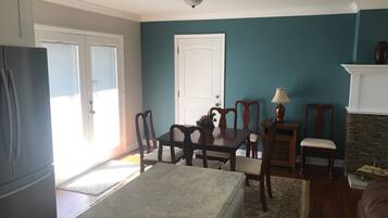 Un salon aux murs de couleur turquoise, une table à manger avec des chaises, une cheminée et un réfrigérateur.