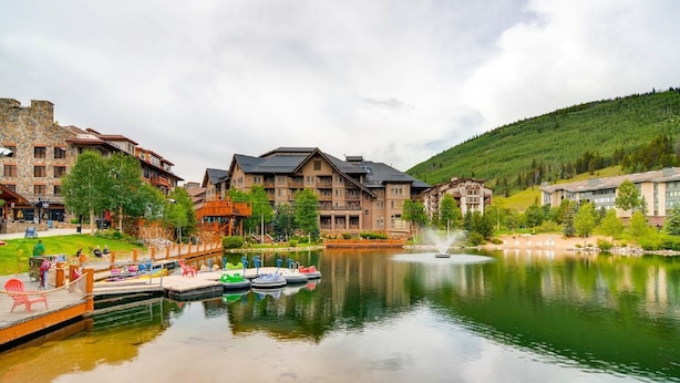 A lakeside hotel with multiple buildings, a dock with boats, and a fountain. - Remodeled unit & mountain view in the ♥ of Central Village, walk to the lifts!  (Frisco)