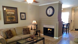A living room with a sofa, coffee table, fireplace, and a clock on the wall. - McCormack Ranch 1st floor 2 Bed 2 Bath Condo.  Located Near Shopping, Dinning.  (Scottsdale)