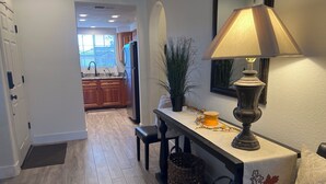 A hallway with a wooden floor, a bench, a table with a lamp, a potted plant, and a decorative vase. - McCormack Ranch 1st floor 2 Bed 2 Bath Condo.  Located Near Shopping, Dinning.  (Scottsdale)