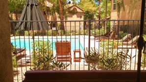 A poolside view with a covered seating area, a pool, and surrounding greenery. - McCormack Ranch 1st floor 2 Bed 2 Bath Condo.  Located Near Shopping, Dinning.  (Scottsdale)