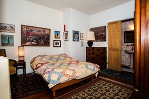 A bedroom with a wooden bed, a nightstand, a lamp, and a large painting on the wall. - Charming Maître Albert 2BR/2BA near Seine, St. Germain and Notre-Dame (Paris)