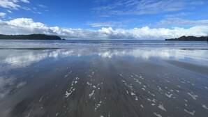 Une plage avec un ciel dégagé et une eau calme.