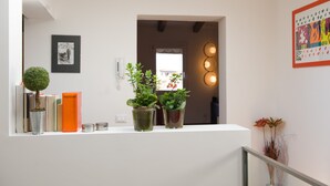 A reception desk with a potted plant, books, and a framed picture on the wall.