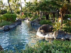 Un'area piscina tranquilla con acqua cristallina, circondata da rocce e vegetazione lussureggiante.