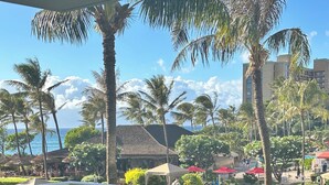 A resort pool area with lounge chairs, umbrellas, and a view of the ocean. - Wow!-Best of HK-Inner Courtyard-Ocean Views-Steps to Beach & Pool-100+ Reviews (Lahaina)